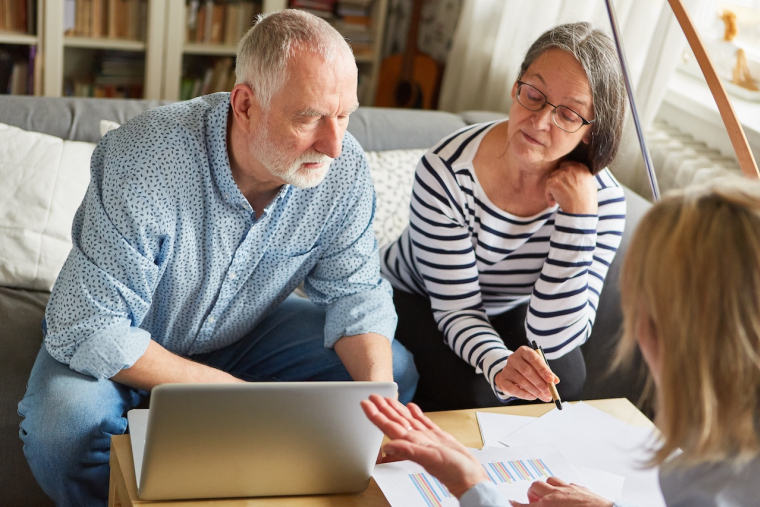Couple de seniors en consultation avec un conseiller patrimonial pour choisir entre PER et assurance vie
