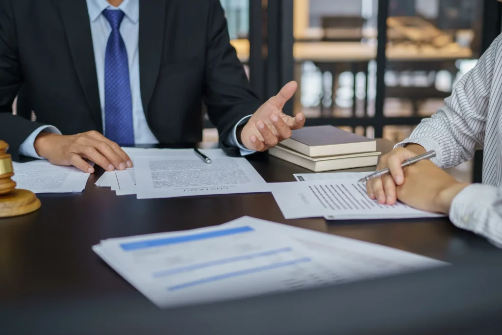 Un conseiller en gestion de patrimoine explique la structuration d'une holding SPFPL à un professionnel libéral autour de documents contractuels.