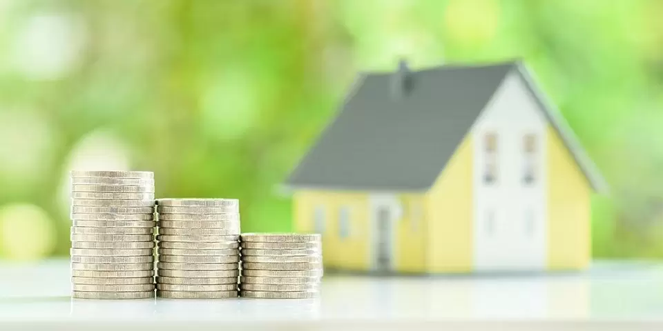 Une maison avec de la monnaie devant qui représente l'impôt sur la fortune