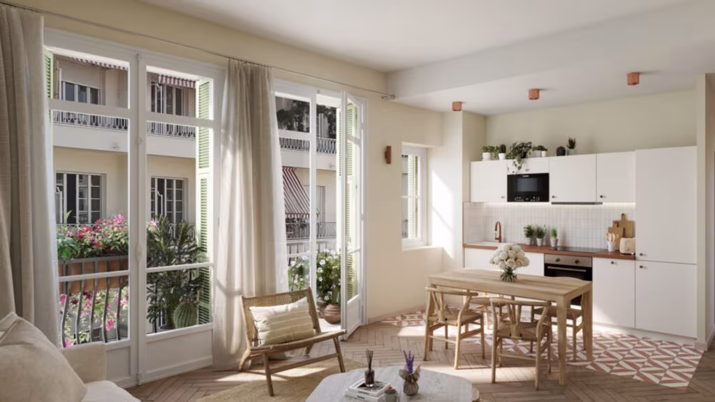 Salon et cuisine ouverte d'un appartement meublé haussmannien, avec balcon fleuri, illustrant un bien LMNP soumis aux nouvelles obligations 2026